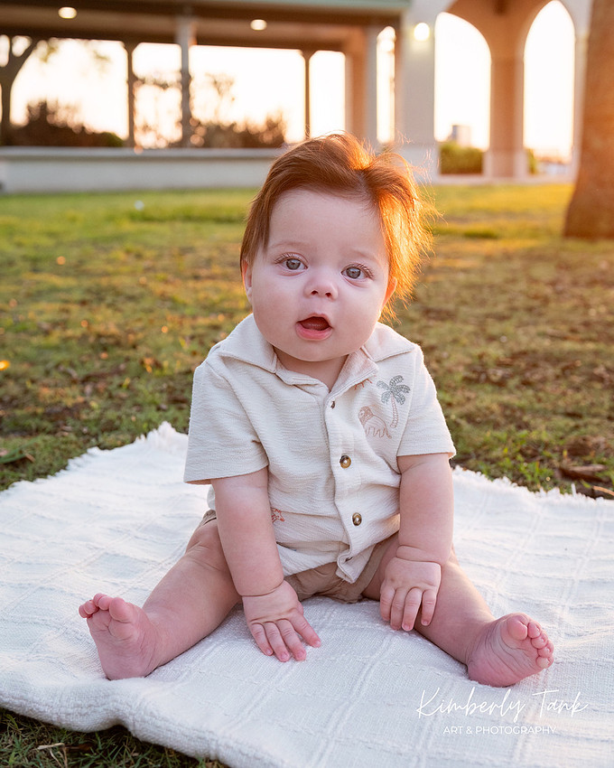 6 month old baby smiling big with mom at sunrise