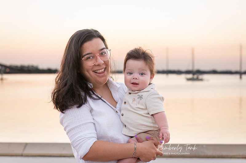 6 month old baby smiling big with mom at sunrise