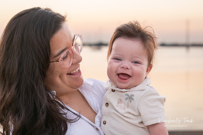 6 month old baby smiling big with mom at sunrise